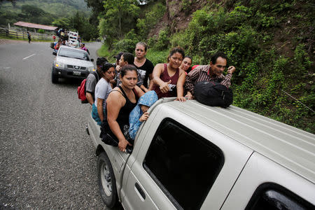 Honduran migrants, part of a caravan trying to reach the U.S., are seen on a truck during a new leg of their travel in Esquipulas, Guatemala October 16, 2018. REUTERS/Jorge Cabrera