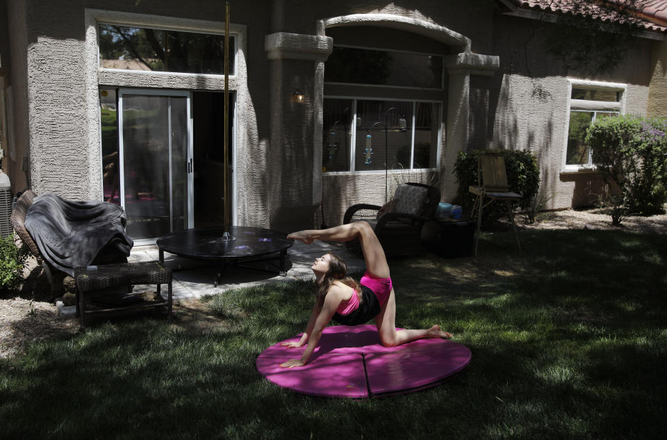 Hand balancer Nataliia Istratova works out on a mat behind her apartment Saturday, June 20, 2020, in Henderson, Nev. "The most important thing is to be on stage," said Istratova who has been working out at home four or five days a week while the show she performs in, "WOW - The Vegas Spectacular" is closed due to the coronavirus. (AP Photo/John Locher)