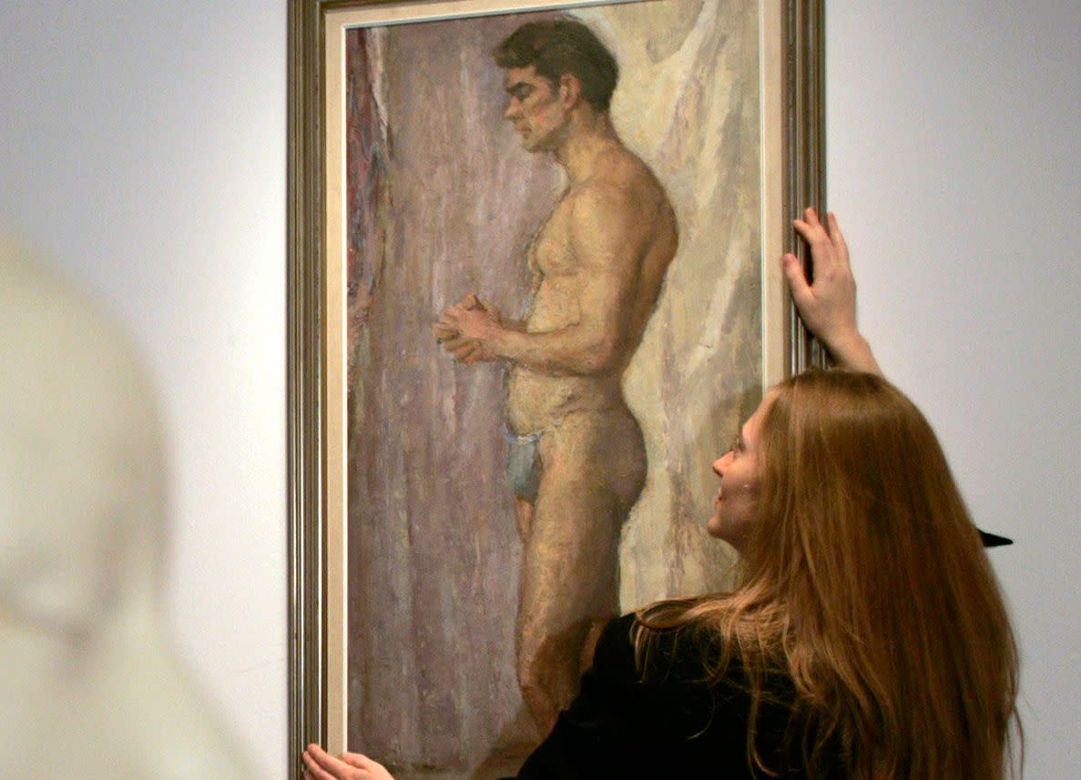 A gallery assistant looks at a 1952 oil on canvas painting of Scottish actor Sean Connery in the Edinburgh College of Art in Scotland on Oct. 25, 2007. Al Fairweather, a student, painted it just before Connery auditioned for the stage production of South Pacific.