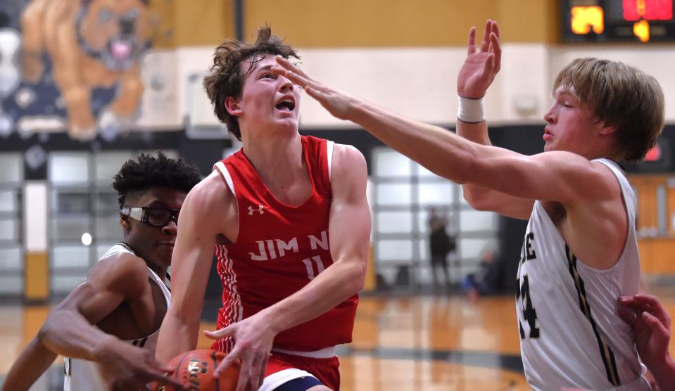 Jim Ned's Hank Ritter, center, drives to the basket as Clyde's Aaron Evans, left, and Jarrett Jeffers defend. Jim Ned beat the Bulldogs 59-35 in the District 6-3A game Friday at Clyde.