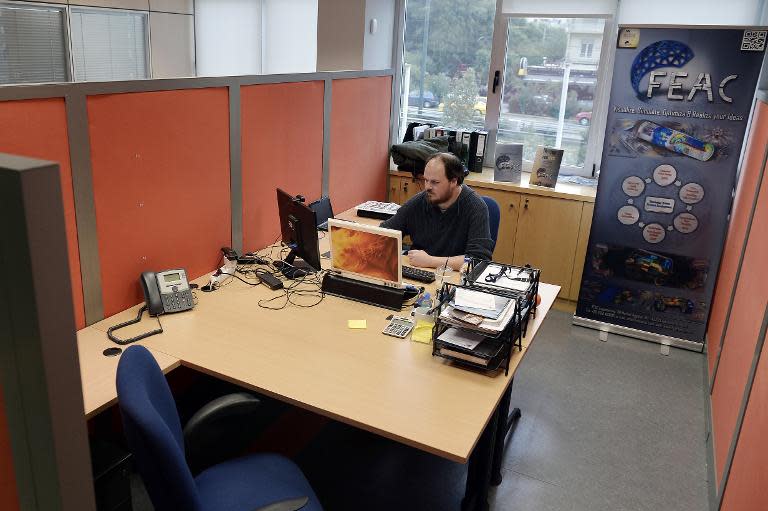 Sotiris Kokkinos, 32, co-founder of FEAC (outsourcing engineering) works in his office in Athens on November 12, 2014
