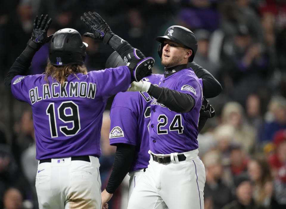 Colorado Rockies' Charlie Blackmon, left, congratulates Ryan McMahon for his three-run home run against the Cincinnati Reds during the fifth inning of a baseball game Friday, April 29, 2022, in Denver. (AP Photo/David Zalubowski)