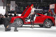 A model poses for photographers in front of the Italdesign Giugiaro Parcour at the 2013 Geneva Motor Show.