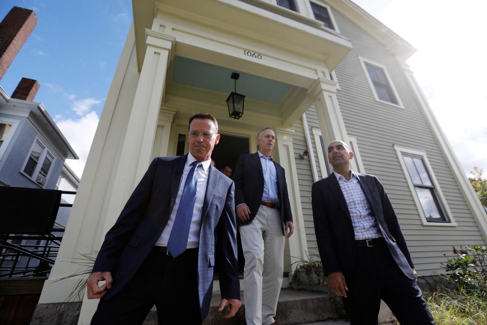 Veterans Transition House Executive Director Jim Reid leads New Bedford Mayor Jon Mitchell and Massachusetts Veterans Services Secretary Jon Santiago during a visit to the Veterans Transition House in New Bedford.