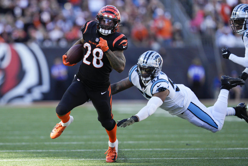 Cincinnati Bengals running back Joe Mixon (28) runs past Carolina Panthers linebacker Damien Wilson (57) during the first half of an NFL football game, Sunday, Nov. 6, 2022, in Cincinnati. (AP Photo/Jeff Dean)