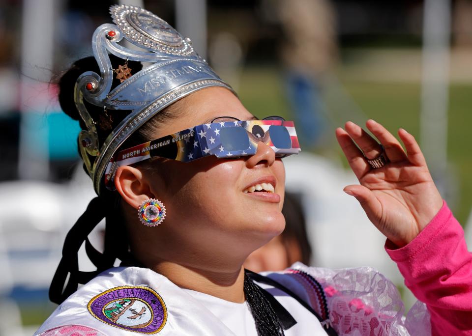 Genesis Talamasey, 2023-2024 Miss Seminole Nation of Oklahoma, uses eclipse glasses to look at the annular solar eclipse during the Red Earth FallFest in downtown Oklahoma City, Saturday, Oct. 14, 2023.