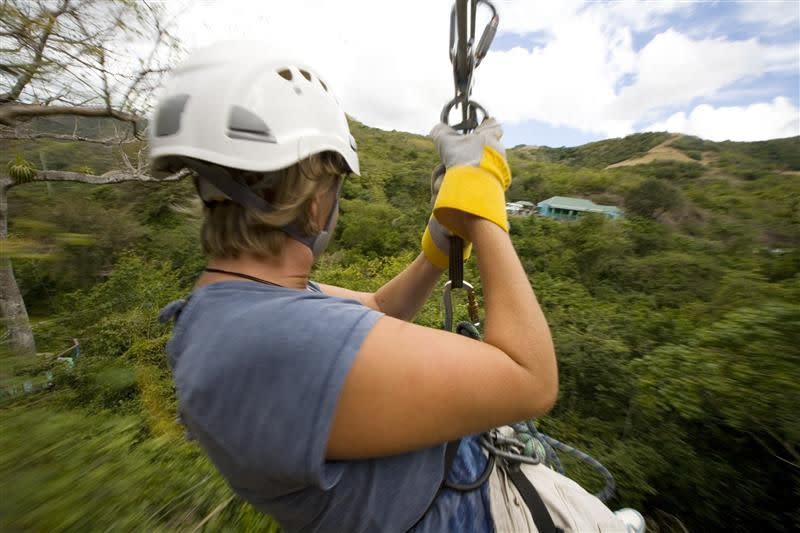 A visitor takes a zipline ride on the Rain Forest Canopy Tour in Antigua.