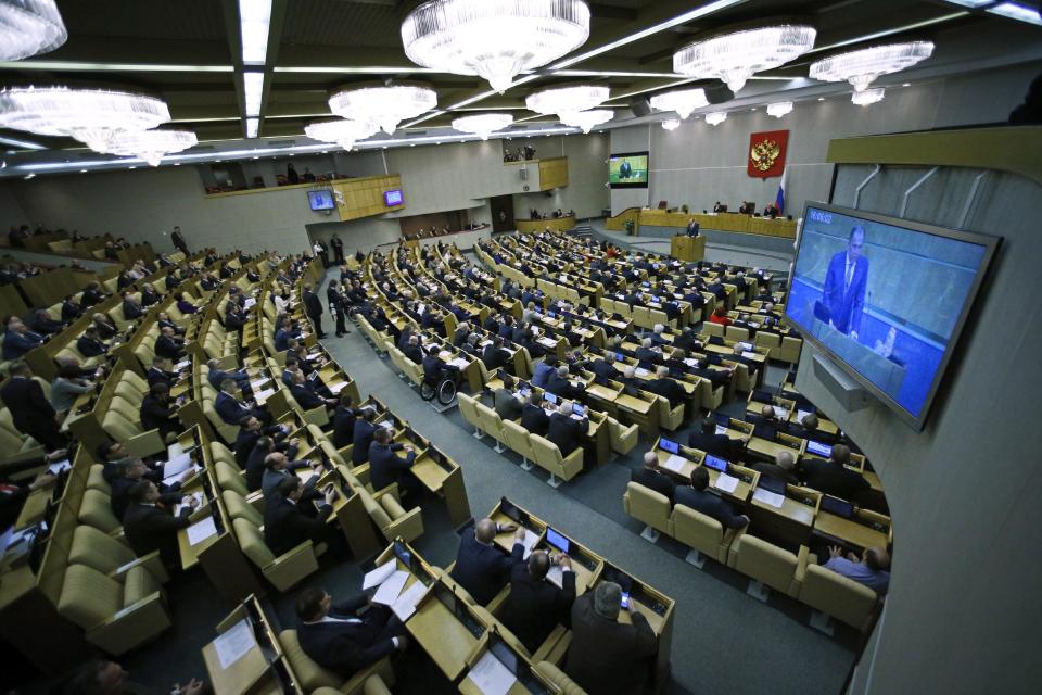 Members of the State Duma, lower parliament chamber, listens to Russian Foreign Minister Sergey Lavrov, seen on the screen, prior their voting during a plenary session in Moscow, Russia, Thursday, March 20, 2014. The Kremlin-controlled State Duma voted Thursday to allow Crimea to join Russia following a quick discussion in which members of the Kremlin-controlled chamber assailed the Ukrainian authorities. The merger needs to be rubber stamped by the upper house and signed by President Vladimir Putin, mere formalities expected to be completed by the end of the week. (AP Photo/Alexander Zemlianichenko)