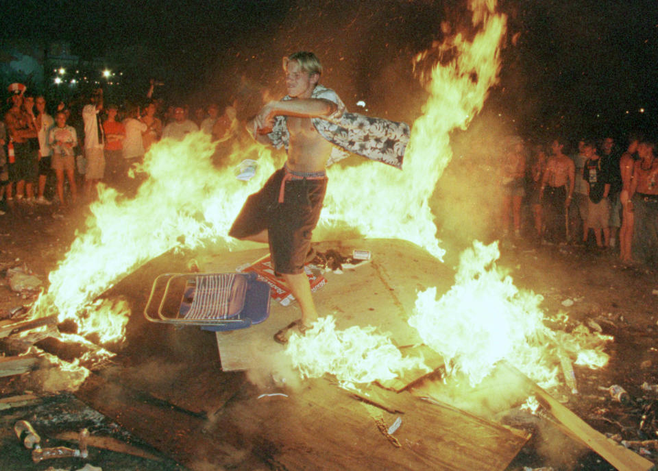 A young man dances in a fire created by plywood panels that had been he Woodstock Peace Wall. (Photo: Joe Traver/Getty Images)