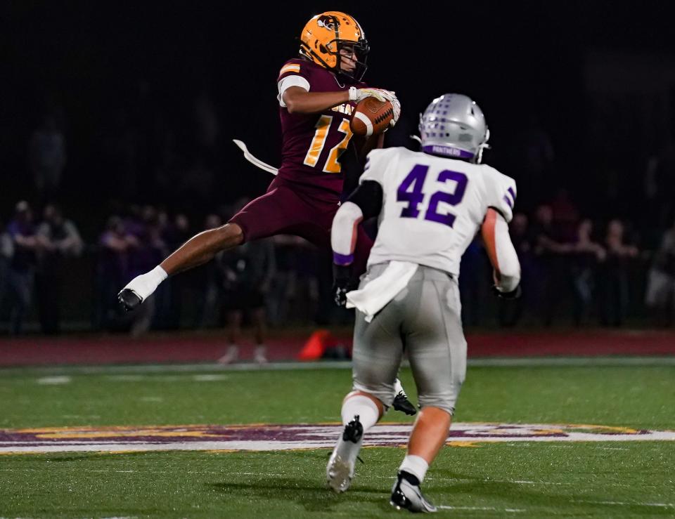 Bloomington North’s Jorian Brooks (12) catches a pass in front of Bloomington South’s Ben Ridner (42) during the IHSAA sectional semi-final football game at Bloomington North on Friday, Oct. 27, 2023.