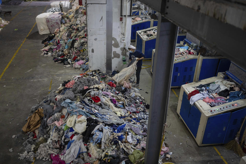 A worker feeds discarded textiles to a shredding machine at the Wenzhou Tiancheng Textile Company, one of China's largest cotton recycling plants in Wenzhou in eastern China's Zhejiang province on March 20, 2024. The recycling factory that repurposes discarded cotton clothes is trying to deal with the urgent waste problem. (AP Photo/Ng Han Guan)