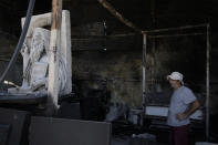 Sculptor Vangelis Ilias stands in the blackened remains of his workshop, which had been burned in a mid-August wildfire, in Halandri suburb in northern Athens, Thursday, Aug. 22, 2024. (AP Photo/Thanassis Stavrakis)