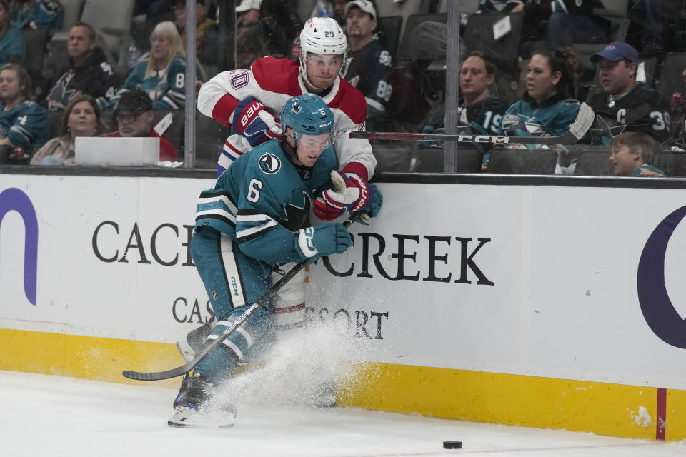 San Jose Sharks defenseman Ty Emberson (6) and Montreal Canadiens left wing Juraj Slafkovsky (20) look toward the puck during the second period of an NHL hockey game in San Jose, Calif., Friday, Nov. 24, 2023. (AP Photo/Jeff Chiu)