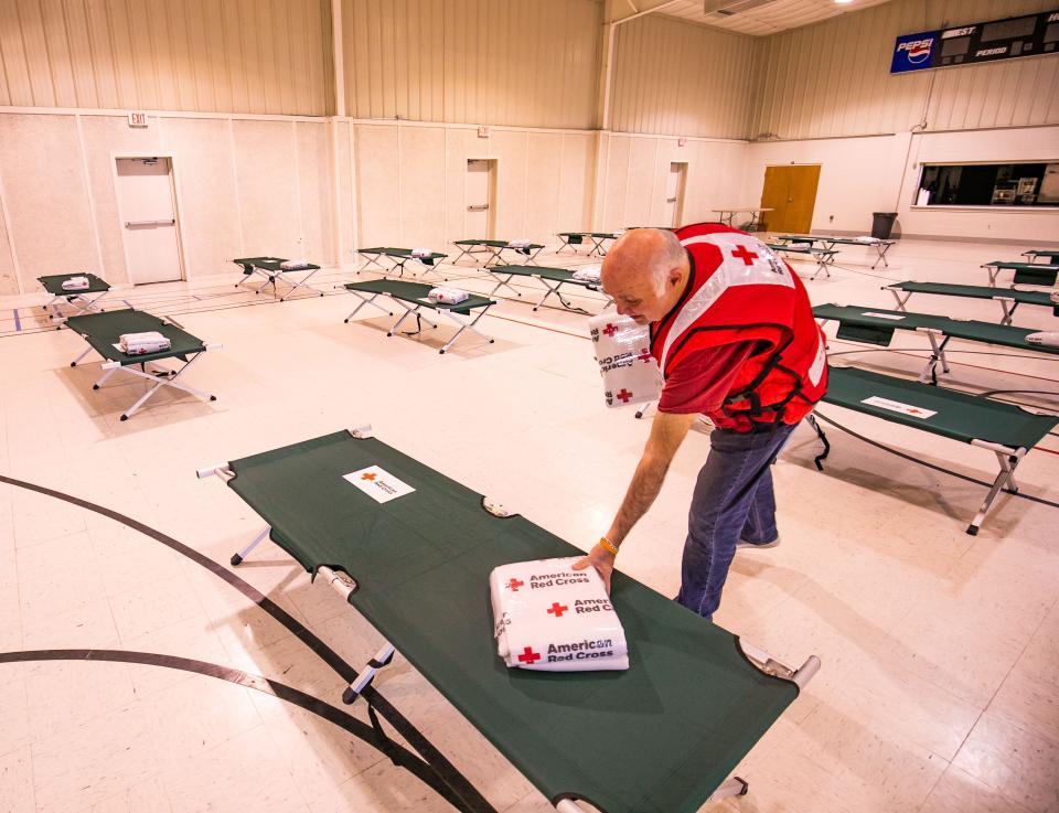 Stan Mingo of the American Red Cross Jacksonville chapter places blankets on cots on Sunday while waiting for displaced residents to arrive at the shelter at the Central Christian Church, 3010 NE 14th St., Ocala.