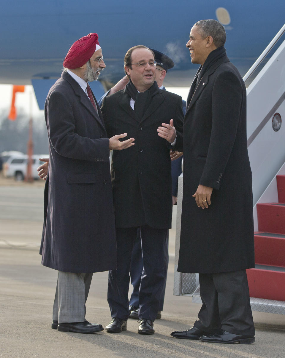 President Barack Obama and French President Francois Hollande, center, are greeted by Charlottesville, Va. Mayor Satyendra Huja upon their arrival on Air Force One at Charlottesville Albemarle Airport, Monday, Feb. 10, 2014, in Charlottesville, Va. Obama and Hollande are traveling to tour Monticello, President Thomas Jefferson's estate in Charlottesville, Va. (AP Photo/Pablo Martinez Monsivais)