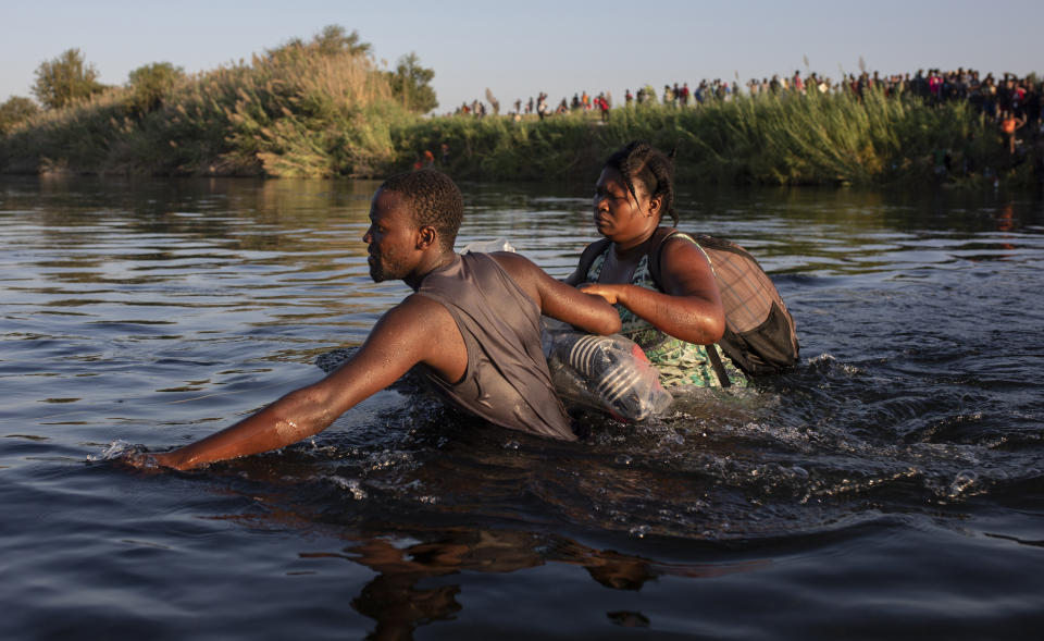 Dos migrantes haitianos cruzan el río Bravo desde Del Río, Texas, hacia Ciudad Acuña, México, el lunes 20 de septiembre de 2021 para evitar ser deportados por Estados Unidos. (AP Foto/Félix Márquez)