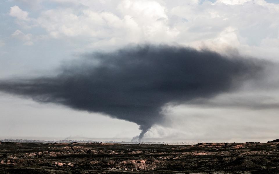 A plume of dark smoke rises over the northern Gaza Strip