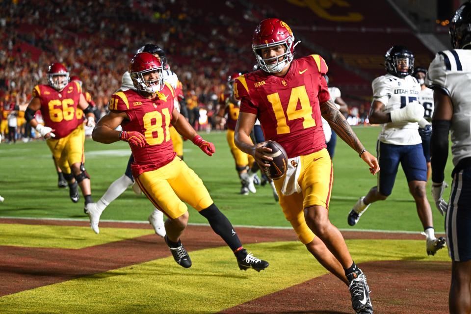 Sep 7, 2024; Los Angeles, California, USA; USC Trojans quarterback Jayden Maiava (14) scores a touchdown against the Utah State Aggies during the fourth quarter at United Airlines Field at Los Angeles Memorial Coliseum. Mandatory Credit: Jonathan Hui-Imagn Images