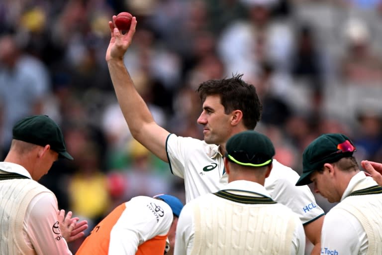 Australia's Pat Cummins raises the ball after taking five wickets against Pakistan (William WEST)