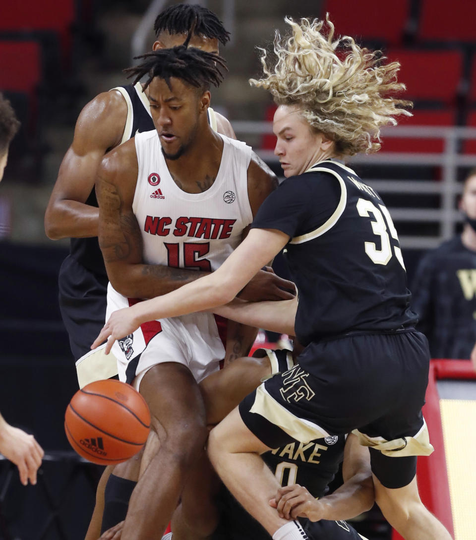 North Carolina State's Manny Bates (15) and Wake Forest's Carter Whitt (35) go for the ball during the first half of an NCAA college basketball game Wednesday, Jan. 27, 2021, in Raleigh, N.C. (Ethan Hyman/The News & Observer via AP, Pool)