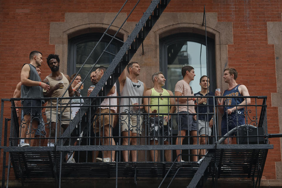 People watch the NYC Pride March from a fire escape, Sunday, June 30, 2024, in New York. (AP Photo/Andres Kudacki)