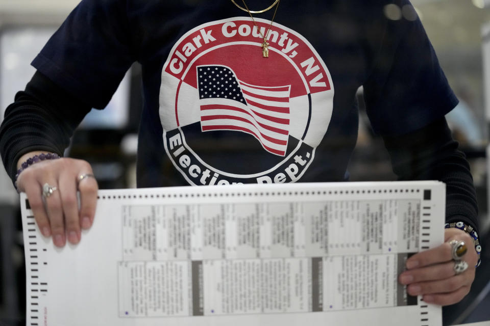 FILE - An election worker tabulates mail-in ballots at the Clark County Election Department on Nov. 9, 2022, in Las Vegas. Republicans are re-evaluating their antipathy to mail voting. After former President Donald Trump condemned that method of casting ballots in 2020, conservatives shied away from it. That's given Democrats a multiweek jump on voting during elections. (AP Photo/Gregory Bull, File)