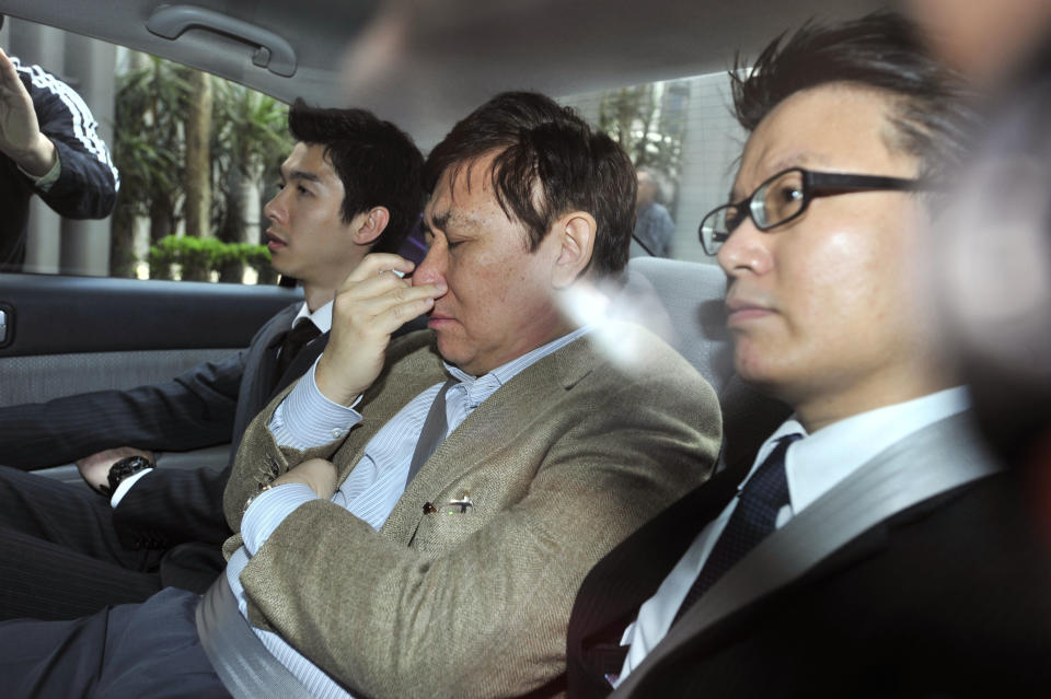 Hong Kong's major property company Sun Hung Kai Properties co-chairmen and managing director Raymond Kwok Ping Luen, center, is escorted in a car by two staff members from the Independent Commission Against Corruption in Hong Kong Thursday, March 29, 2012. Hong Kong's anti-corruption watchdog has arrested two senior executives at a listed company and a former senior government official for suspected corruption. The Independent Commission Against Corruption said Thursday the three are alleged to have committed bribery and misconduct in public office offenses. It did not name them. (AP Photo) HONG KONG OUT, NO SALES, NO ARCHIVES