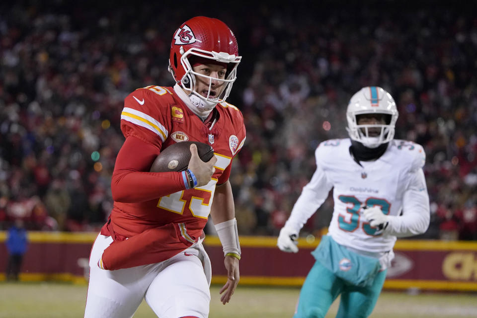 Kansas City Chiefs quarterback Patrick Mahomes (15) runs in front of Miami Dolphins cornerback Eli Apple during the first half of an NFL wild-card playoff football game Saturday, Jan. 13, 2024, in Kansas City, Mo. (AP Photo/Ed Zurga)