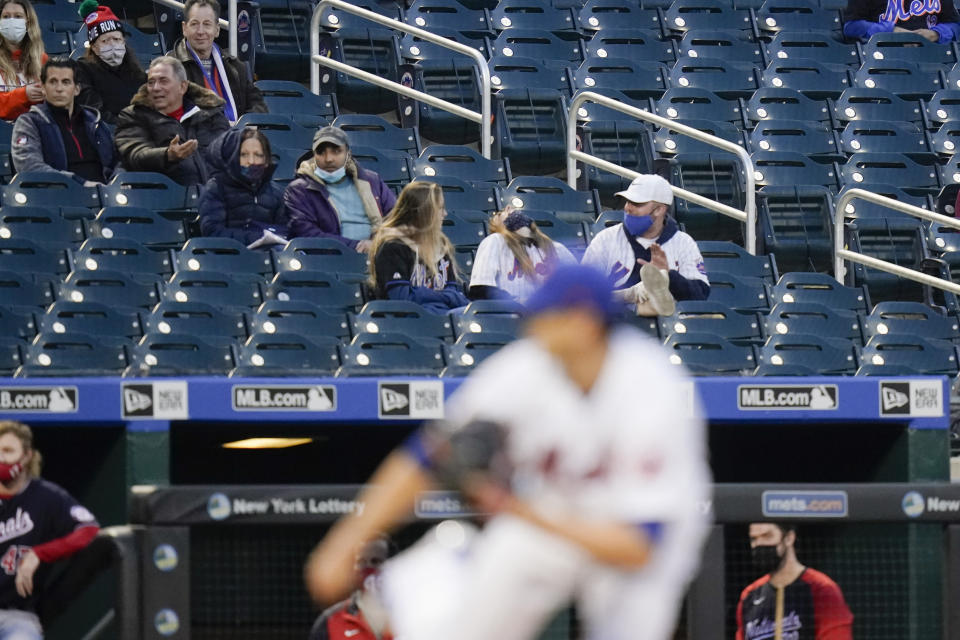 Fans watch as New York Mets' Jacob deGrom delivers a pitch during the second inning of the team's baseball game against the Washington Nationals on Friday, April 23, 2021, in New York. (AP Photo/Frank Franklin II)