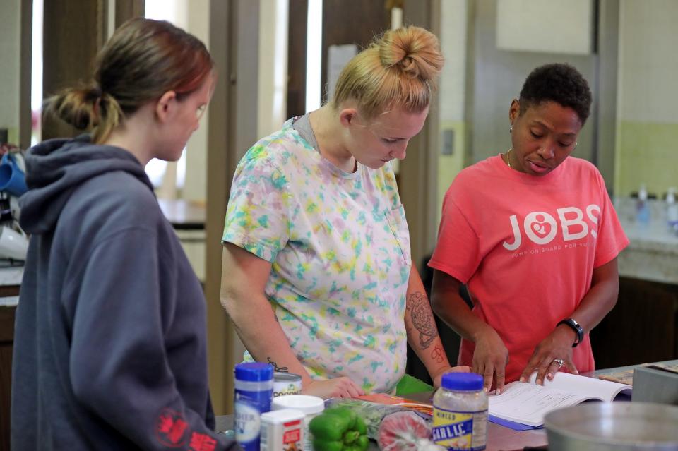 Chef Jen Tidwell, right, works with JOBS students during class.
