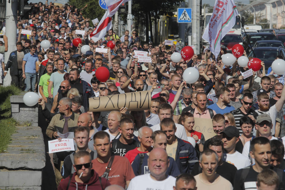 Workers with handmade posters reading "Go away!" march toward the Minsk Wheel Tractor Plant where Belarusian President Alexander Lukashenko addresses employees in Minsk, Belarus, Monday, Aug. 17, 2020. The top opposition candidate in Belarus' presidential vote who left the country last week announced Monday she was ready to "act as a national leader" to help Belarus transition to a rerun of an election that extended the 26-year rule of authoritarian President Alexander Lukashenko and sparked unprecedented mass protests. (AP Photo/Dmitri Lovetsky)