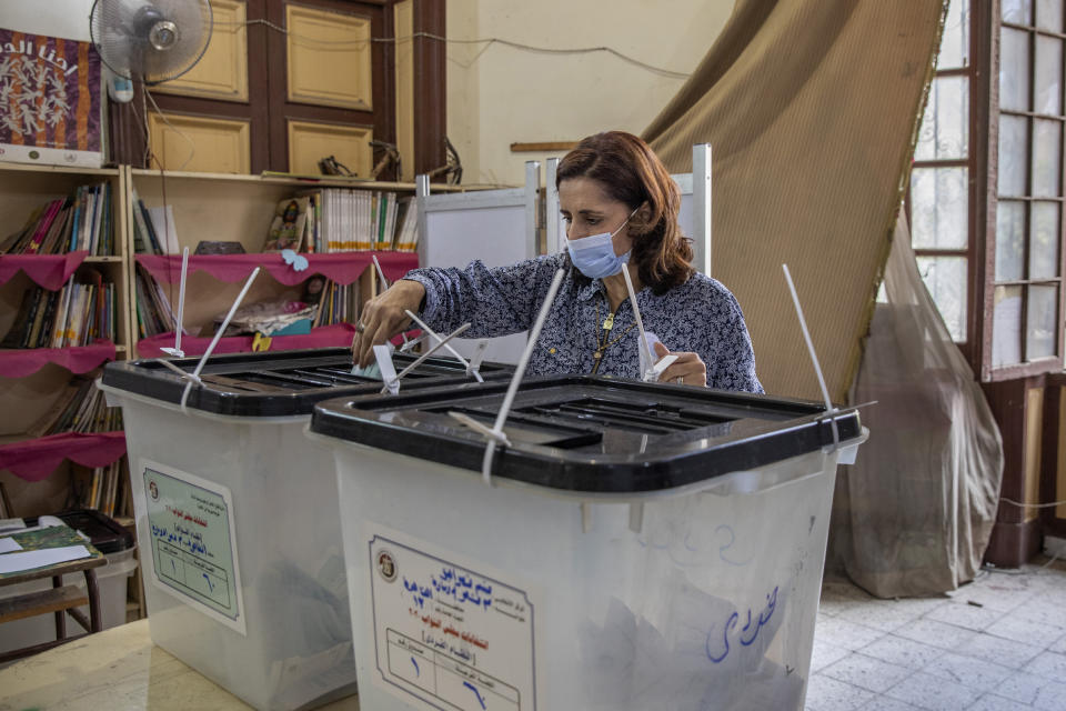 A woman casts her vote on the first day in the second and final stage of the country's parliamentary elections in Cairo, Egypt, Saturday, Nov. 7, 2020. Egyptians began voting on Saturday after a relatively low turnout in the first stage that embarrassed the government of President Abdel-Fattah el-Sissi. (AP Photo/Nariman El-Mofty)