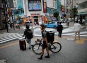 Takenobu Tonegawa walks as he works his part-time job as Uber Eats delivery person amid the coronavirus disease (COVID-19) outbreak, in Tokyo