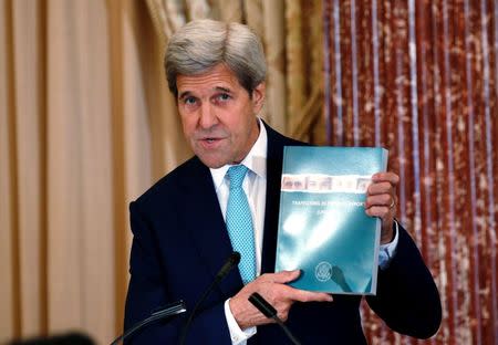 U.S. Secretary of State John Kerry holds up at copy of the 2016 Trafficking in Persons (TIP) report during the TIP Heroes Ceremony at the State Department in Washington, June 30, 2016. REUTERS/Kevin Lamarque