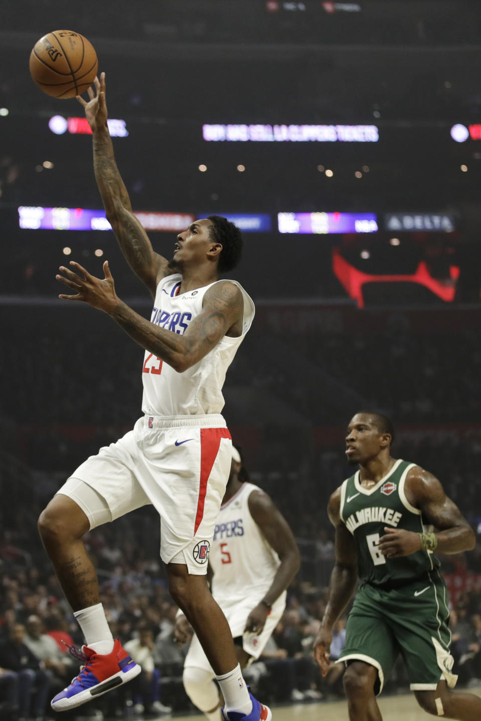 Los Angeles Clippers' Lou Williams, left, shoots in front of Milwaukee Bucks' Eric Bledsoe (6) during the first half of an NBA basketball game Wednesday, Nov. 6, 2019, in Los Angeles. (AP Photo/Marcio Jose Sanchez)