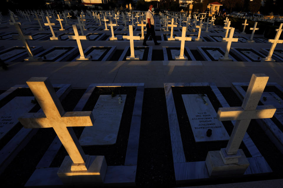 FILE - In this Tuesday, July 20, 2021 file photo, a man walks by the graves of soldiers killed in the 1974 Turkish invasion of Cyprus in the Tymvos Macedonitissas military cemetery during the 47th anniversary in the divided capital of Nicosia, Cyprus. Nikos Christodoulides, the foreign minister of the divided island of Cyprus is accusing Turkey's president of attempting to promote a new Ottoman empire in the eastern Mediterranean and the Middle East — and says such an approach to geopolitics could adversely impact regional security. Christodoulides was interviewed Monday, Sept. 27, the final day of the U.N. General Assembly’s annual high-level gathering of world leaders. (AP Photo/Petros Karadjias, File)