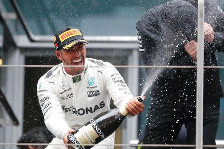 Formula One - F1 - Chinese Grand Prix - Shanghai, China - 09/04/17 - Mercedes driver Lewis Hamilton of Britain celebrates with champagne on the podium after winning the Chinese Grand Prix at the Shanghai International Circuit. REUTERS/Aly Song