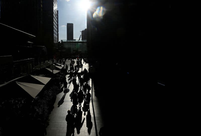 Workers walk through the Canary Wharf financial district in London