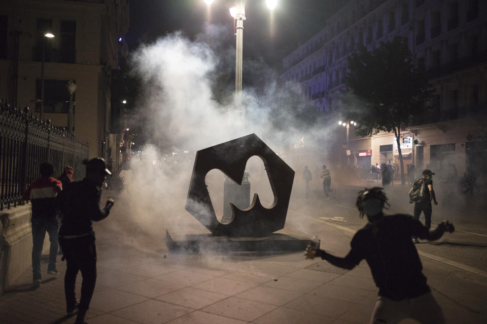 A tear gas canister fired by French riot police engulfs a Marseille statue during a protest in Marseille, southern France, Saturday, June 6, 2020. Protesters marched against the recent death of George Floyd, a black man, who died after he was restrained by police officers May 25 in Minneapolis, that has led to protests in many countries and across the U.S. Further protests are planned over the weekend in European cities, some defying restrictions imposed by authorities due to the coronavirus pandemic. (AP Photo/Daniel Cole)