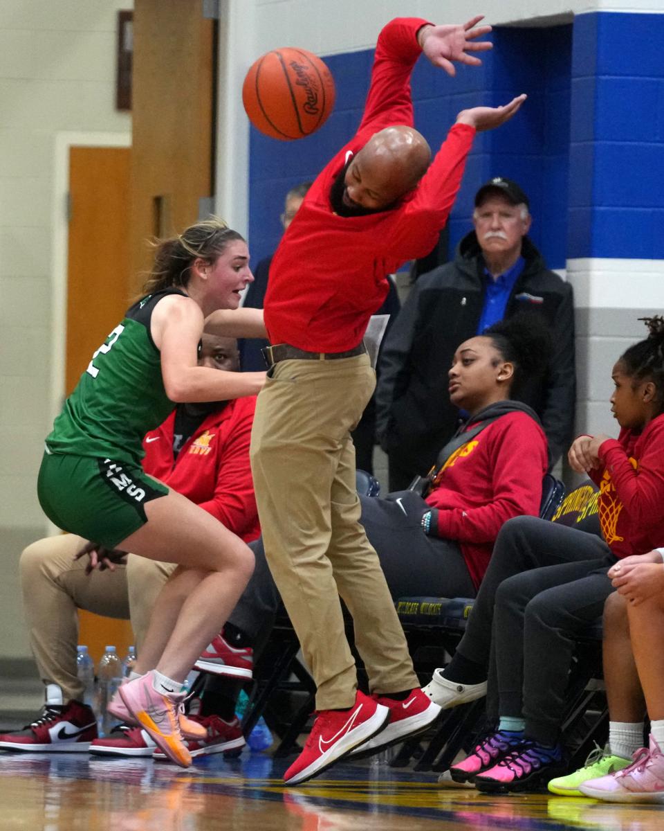 Purcell Marian Cavaliers head coach Jamar Mosley avoids an attempt to save the ball from going out of bounds by Badin Rams forward Braelyn Even (2) in the first half of an OHSAA Division II girls regional final game, Friday, March 8, 2024, at Springfield High School in Springfield, Ohio.