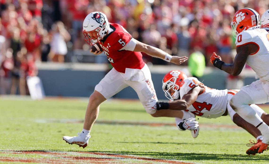 N.C. State’s Brennan Armstrong (5) escapes Clemson linebacker Jeremiah Trotter Jr. (54) on a run in the first half of N.C. State’s game against Clemson at Carter-Finley Stadium in Raleigh, N.C., Saturday, Oct. 28, 2023. Ethan Hyman/ehyman@newsobserver.com