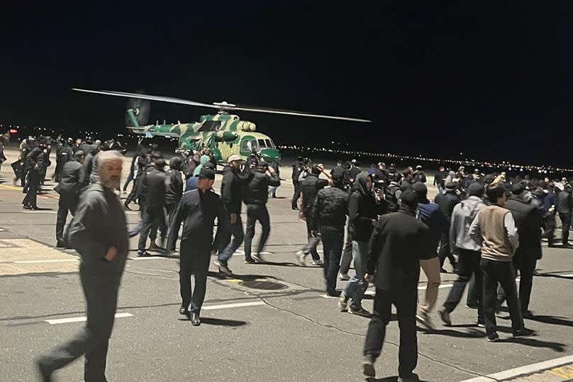 People in the crowd walk shouting antisemitic slogans at an airfield of the airport in Makhachkala, Russia, Monday, Oct. 30, 2023.