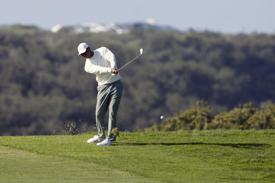 Tiger Woods plays his second shot from the 13th fairway on the Torrey Pines South Course during the second round of The Farmers Insurance golf tournament in San Diego, Friday, Jan. 24, 2020. A police officer working crowd control accepted a bet against Tiger and handed the $20 winnings to a young boy. (AP Photo/Alex Gallardo)