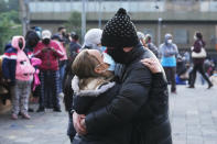 A couple embrace as they wait for a COVID-19 testing center to open, in Quito, Ecuador, Tuesday, Jan. 11, 2022. The provincial government center is offering low-cost COVID PCR tests as an upsurge in infections is feared following the holiday season. (AP Photo/Dolores Ochoa)