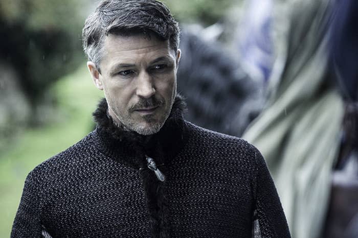 Littlefinger wears a dark cloak and looks serious