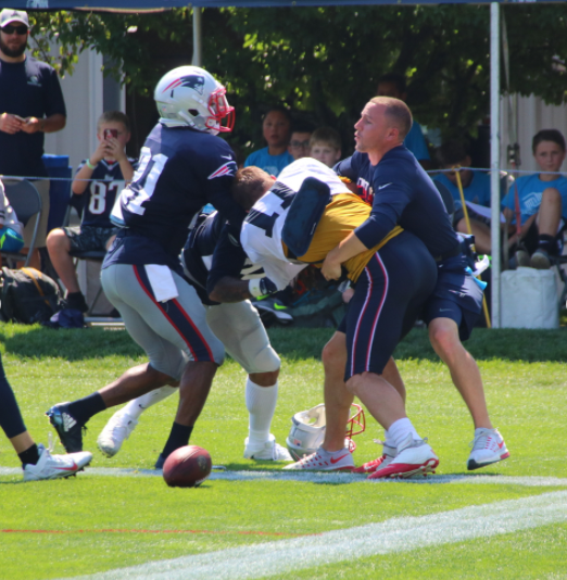 Patriots CB Stephon Gilmore, left, and Julian Edelman, center, fight at practice on Tuesday while a team staff member tries to separate them. (Shaun Ganley/Instagram)