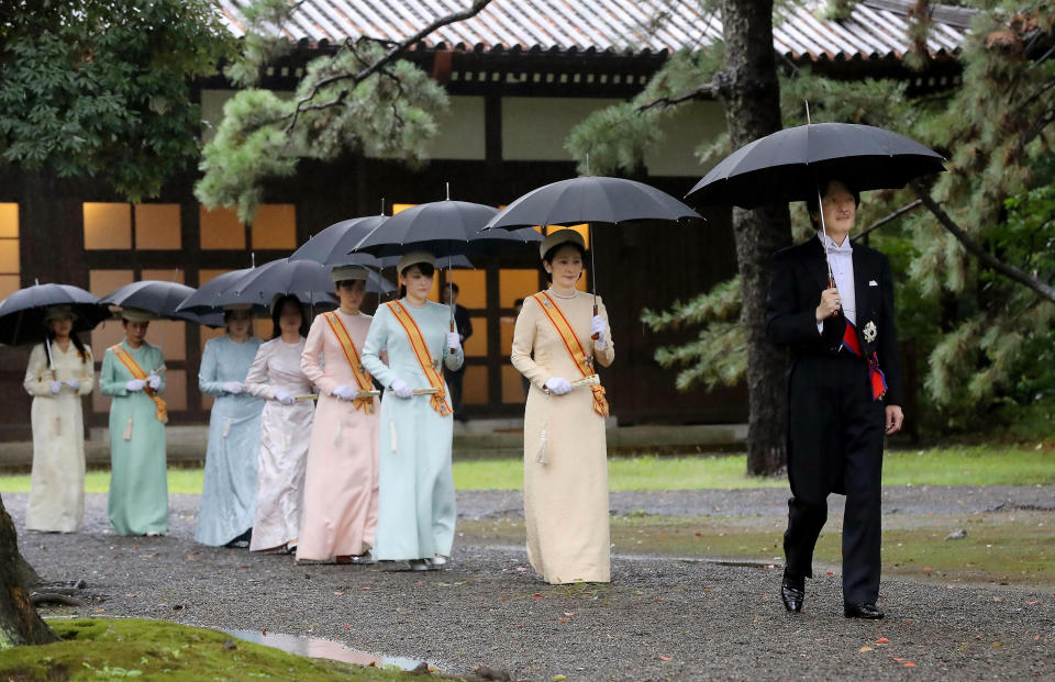 Japan's Crown Prince Akishino, right, and Crown Princess Kiko, second from right, arrive for the ceremony at "Kashikodokoro", one of three shrines at the Imperial Palace, in Tokyo, Tuesday, Oct. 22, 2019. Emperor Naruhito and Empress Masako visited three Shinto shrines at the Imperial Palace before Naruhito proclaims himself Japan’s 126th emperor in an enthronement ceremony. (Kyodo News via AP)