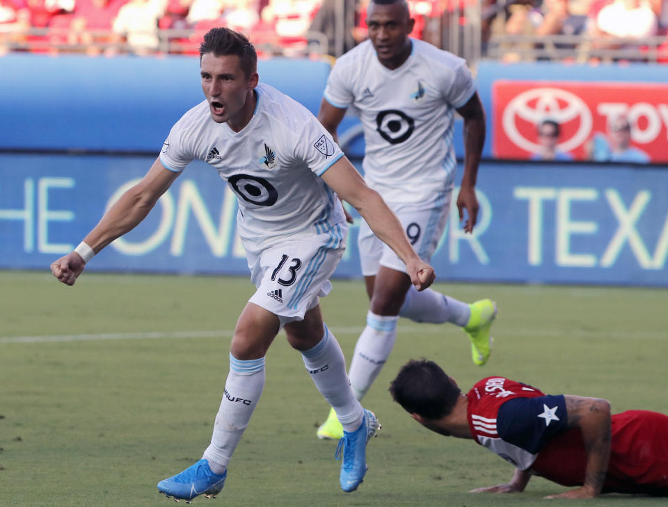 FILE - In this Aug. 10, 2019, file photo, Minnesota United's Ethan Finlay (13) and Angelo Rodriguez, rear left, celebrate Finlay's goal against FC Dallas in the first half of an MLS soccer match in Frisco, Texas. Major League Soccer and its players' union reached an agreement that paves the way for a summer tournament in Florida after the season was suspended by the coronavirus pandemic. The deal was announced by the Major League Soccer Players Association early Wednesday, June 3, 2020, following tense talks that led to some players skipping voluntary workouts and the league threatening a lockout. (AP Photo/Tony Gutierrez, File)