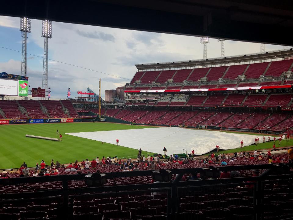 The Great American Ball Park grounds crew puts a tarp over the infield during a rain delay before a Cincinnati Reds-San Diego Padres game on Tuesday, June 29, 2021.
