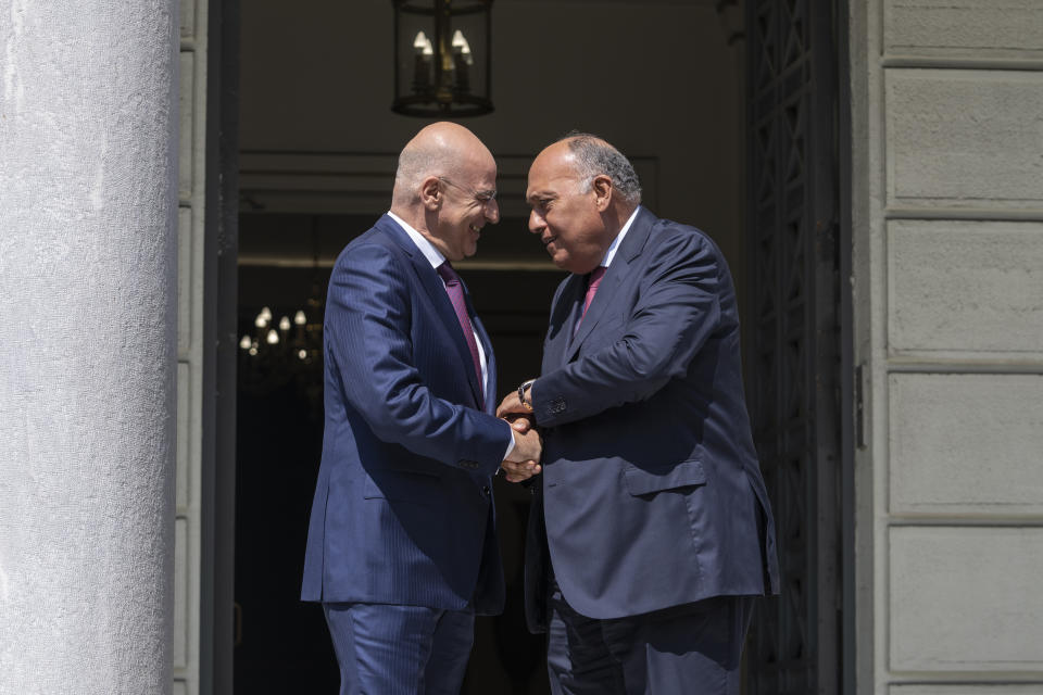 Greek Foreign Minister, Nikos Dendias, left, welcomes his Egyptian counterpart Sameh Shoukry , as they meet in Athens on Tuesday, April 11, 2023. Greece and Egypt have close military ties and are planning to build an undersea electricity grid connector across the Mediterranean. (AP Photo/Petros Giannakouris)